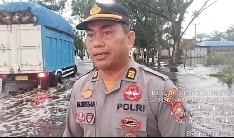 Ingatkan Pengendara Agar Waspada, Anggota Polres Rohil : Luapan Air Semakin Tinggi